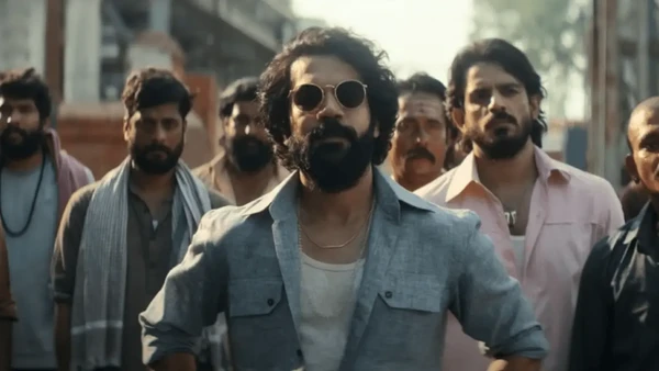 The lead man stands among his followers in a street scene in "Maalik".