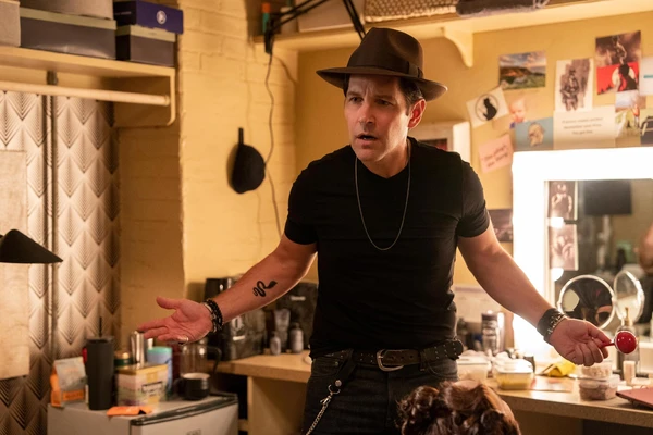 A supporting character gestures expressively in a room in "Only Murders in the Building".