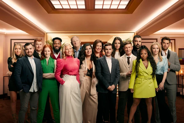 All participants of "Rise and Fall" stand together in a luxurious - looking room.