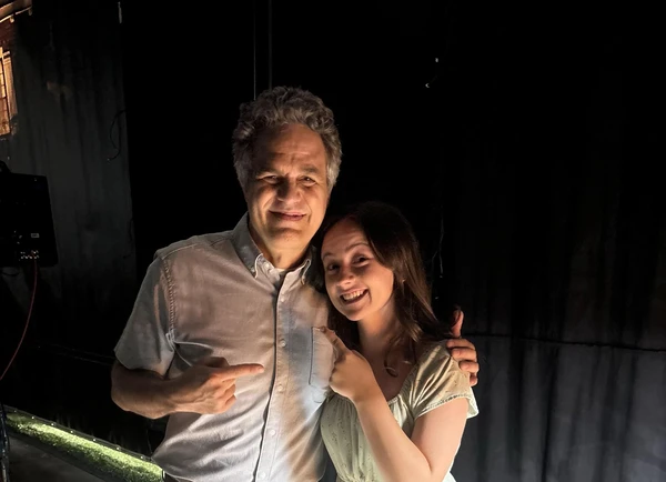 Behind - the - scenes photo of a cast member and another person smiling in "Task".