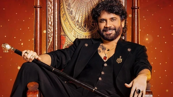 The host of "Bigg Boss Telugu" sits on an ornate throne, holding a scepter.
